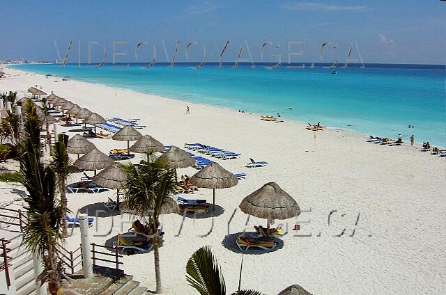 Mexique Cancun Grand Oasis Cancun La plage continue sur plus de 6 kilomètres vers le nord.  De nombreux parasols et chaises longues sur la plage.