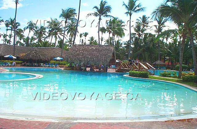 Republique Dominicaine Punta Cana Grand Palladium Palace Resort La piscine du Palace. Un petit pont pour traverser au millieu de la piscine. Le bar sous la hutte offre des siège dans la piscine.